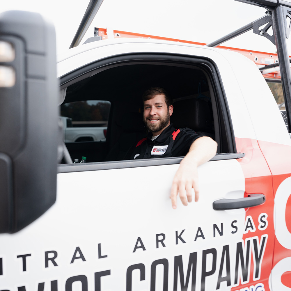 A man in a Central Arkansas Service Company van, emphasizing community service and reliability.